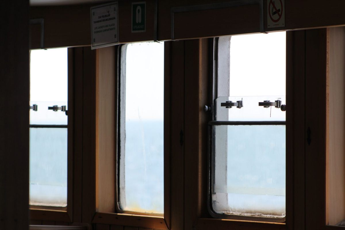 The sea seen through a row of wood-framed ship windows